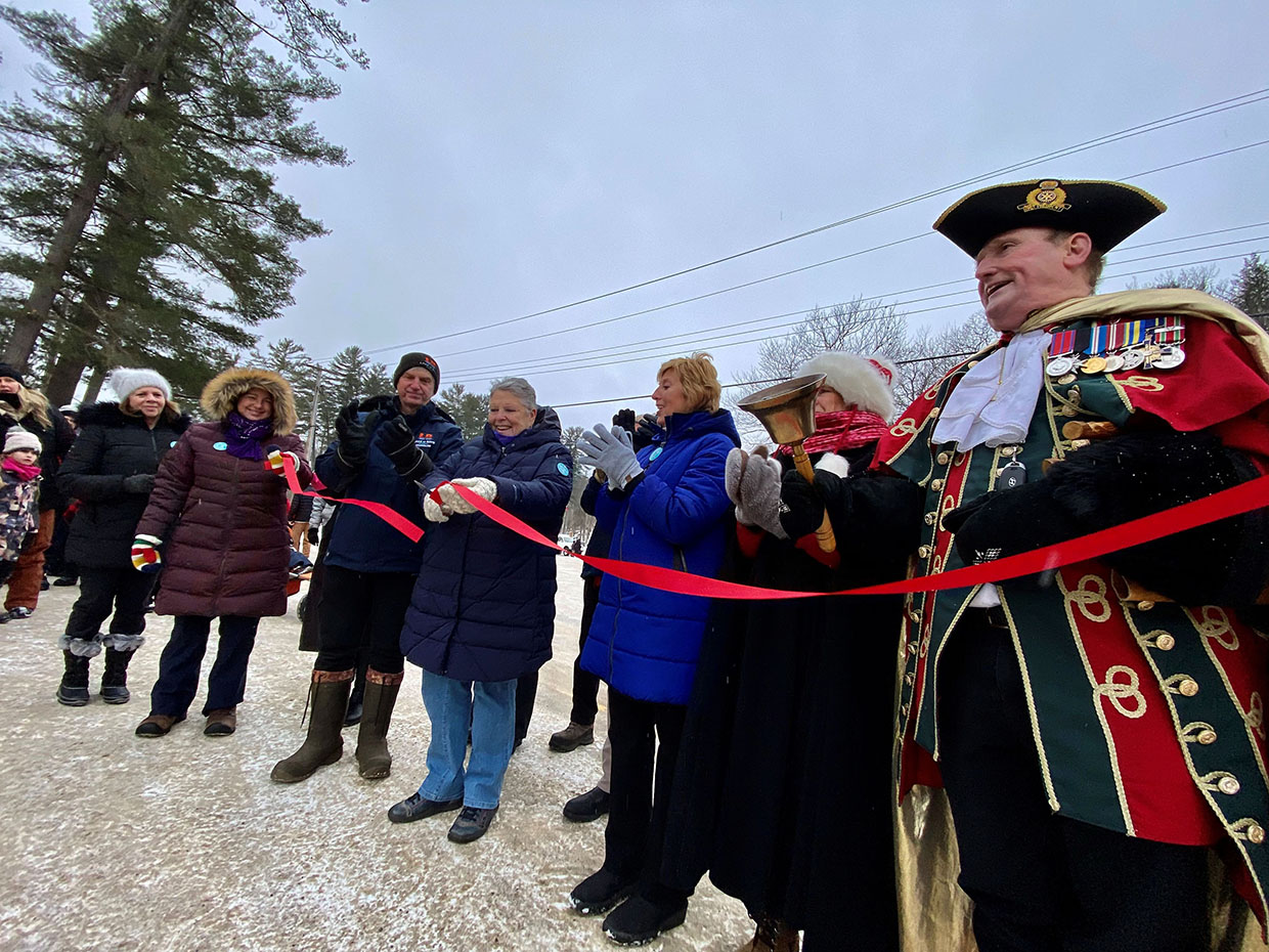 Image shows the mayor and other dignitaries cutting the ceremonial ribbon at the Dorset Snow Ball Winter Carnival. 