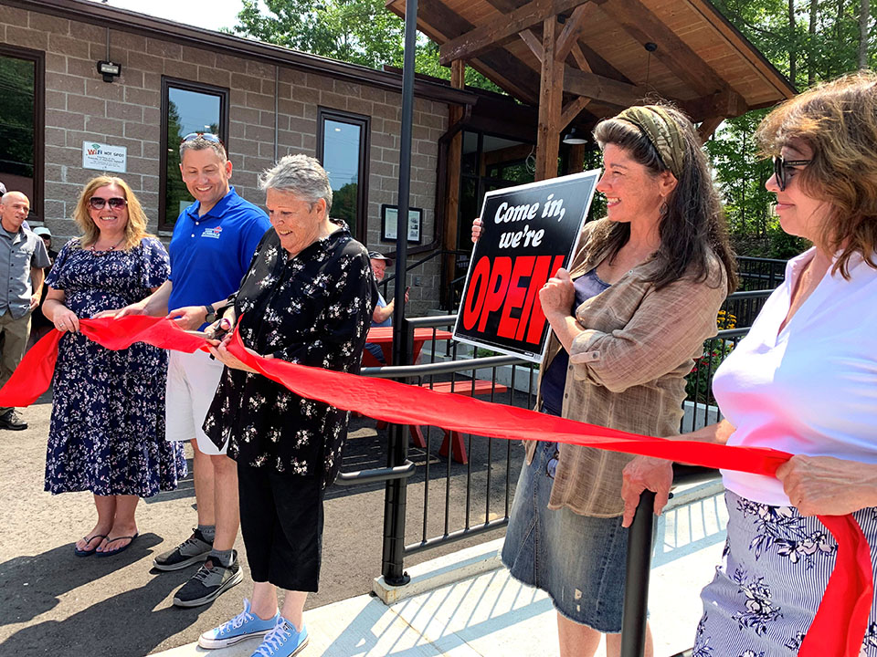Image shows Algonquin Highlands Council cutting a ribbon in front of the Dorset Recreation Centre.
