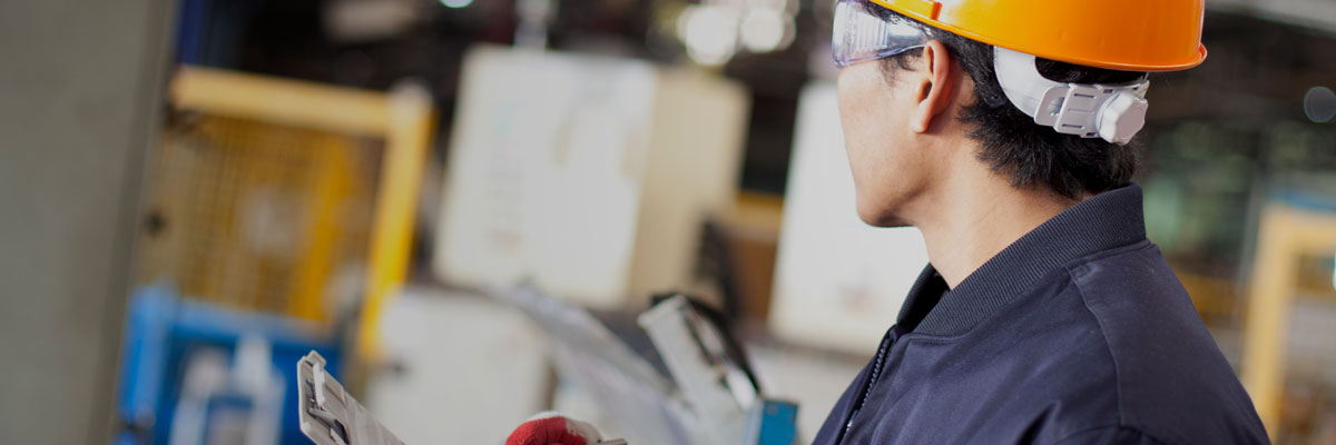 Worker checking products on factory floor