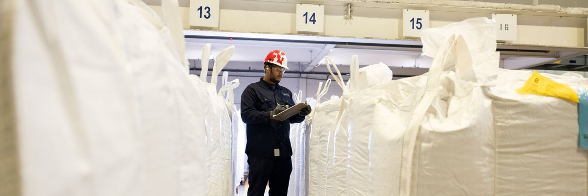Worker with bagged raw materials in factory