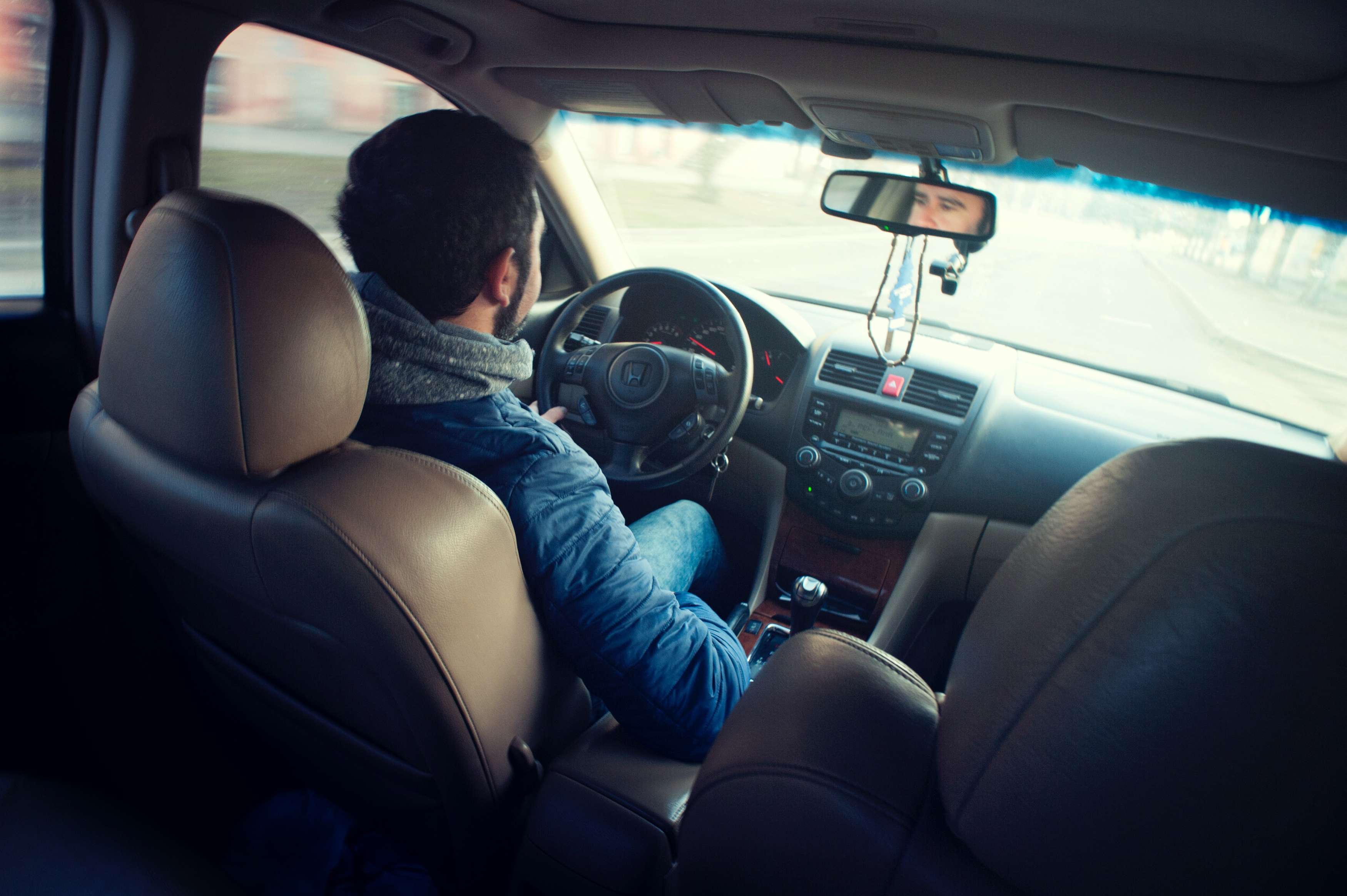 A person driving a car during the day.