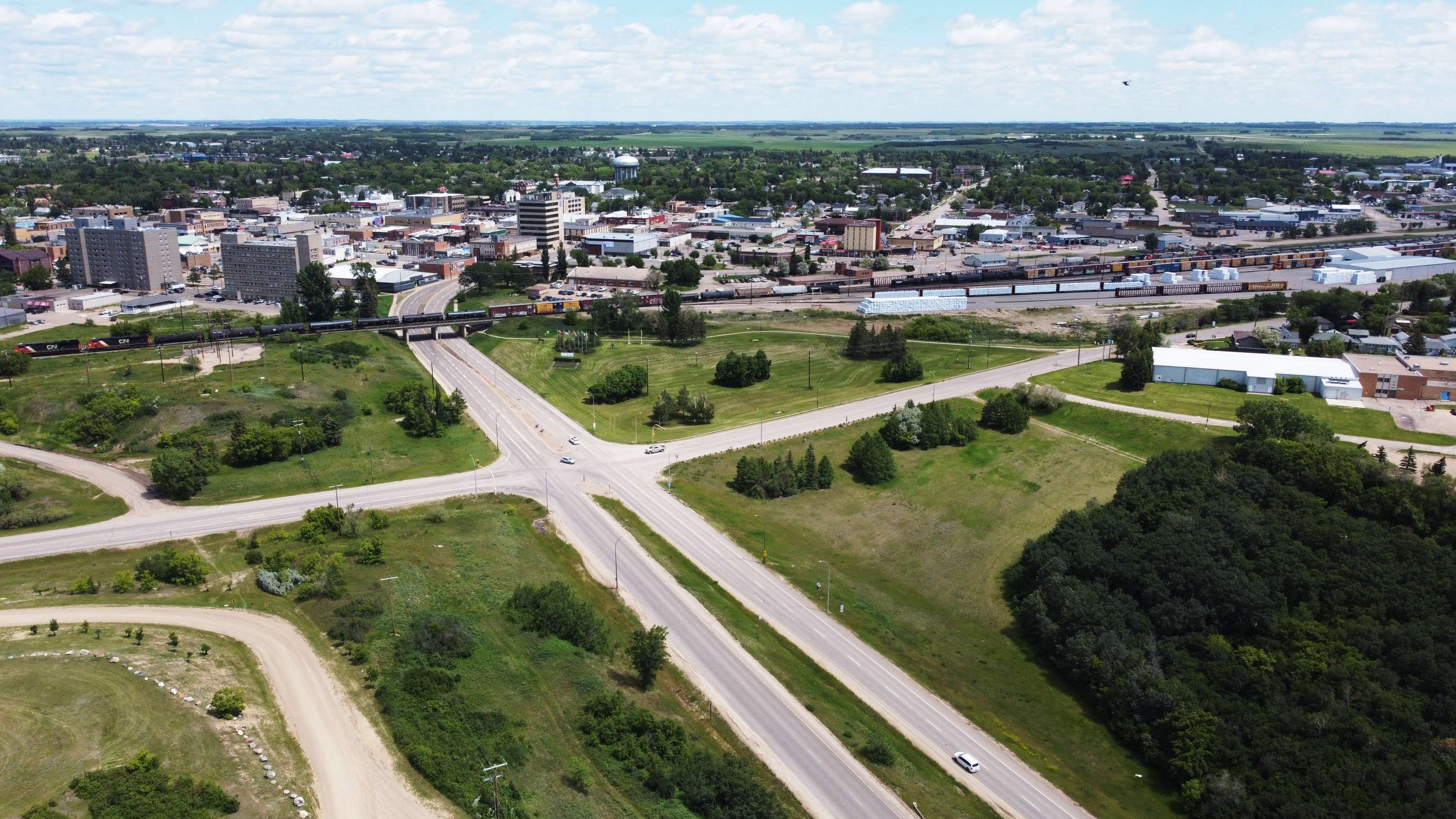 Aerial view of North Battleford with highways, green space, and the downtown core in the distance.