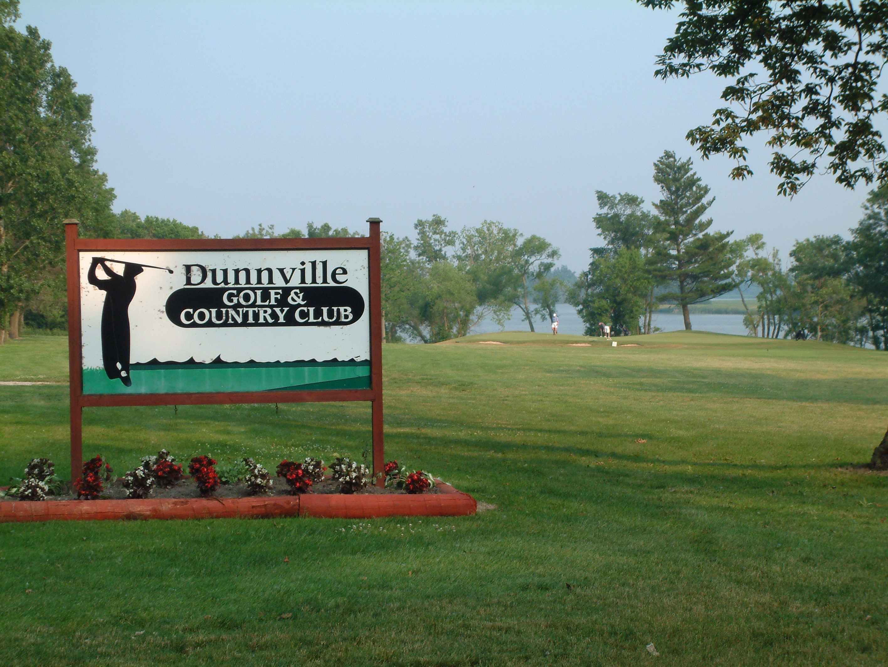 dunnville golf sign with flower bed underneath and golf course behind