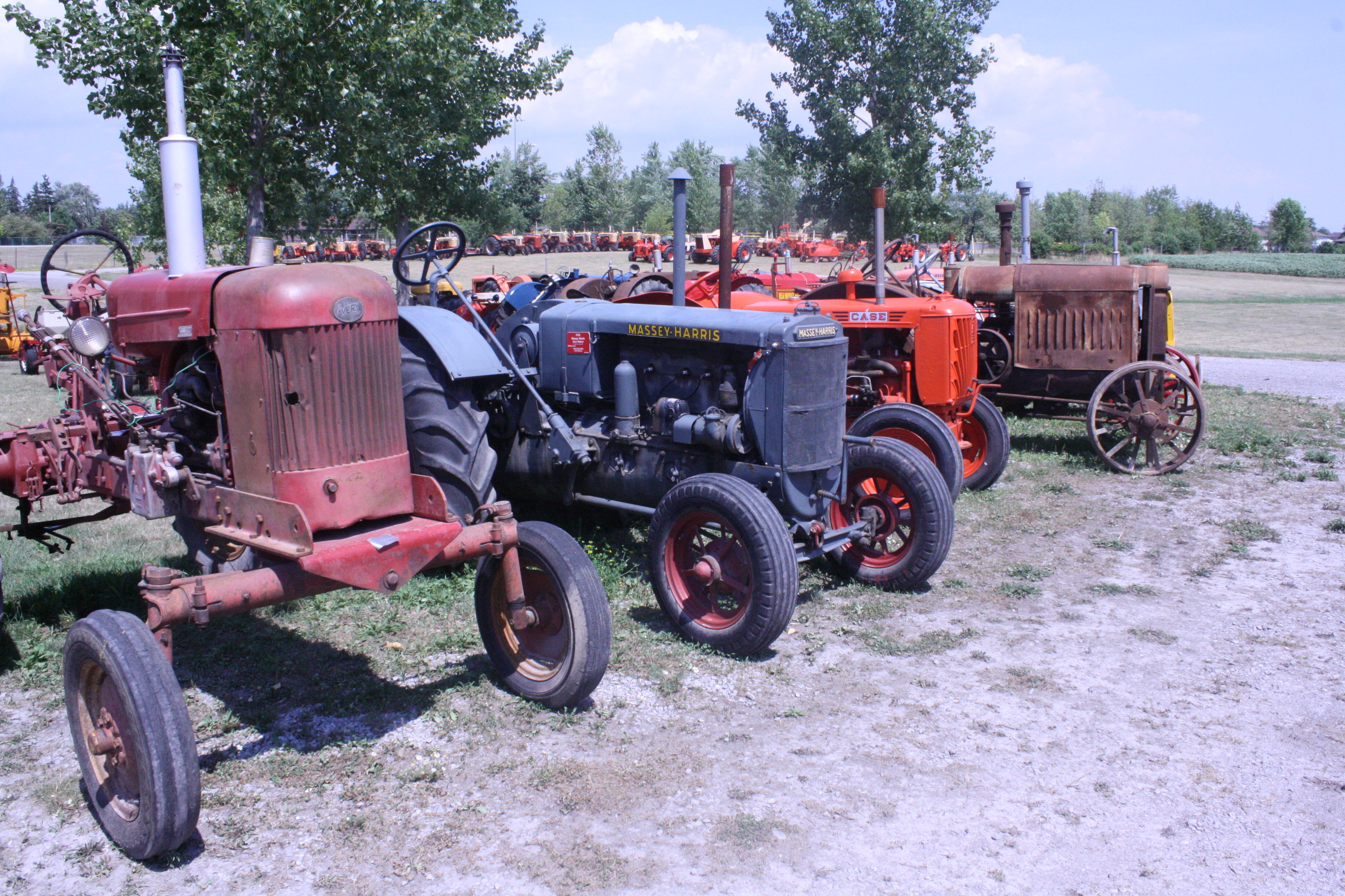 Antique tractors sit on display in a field