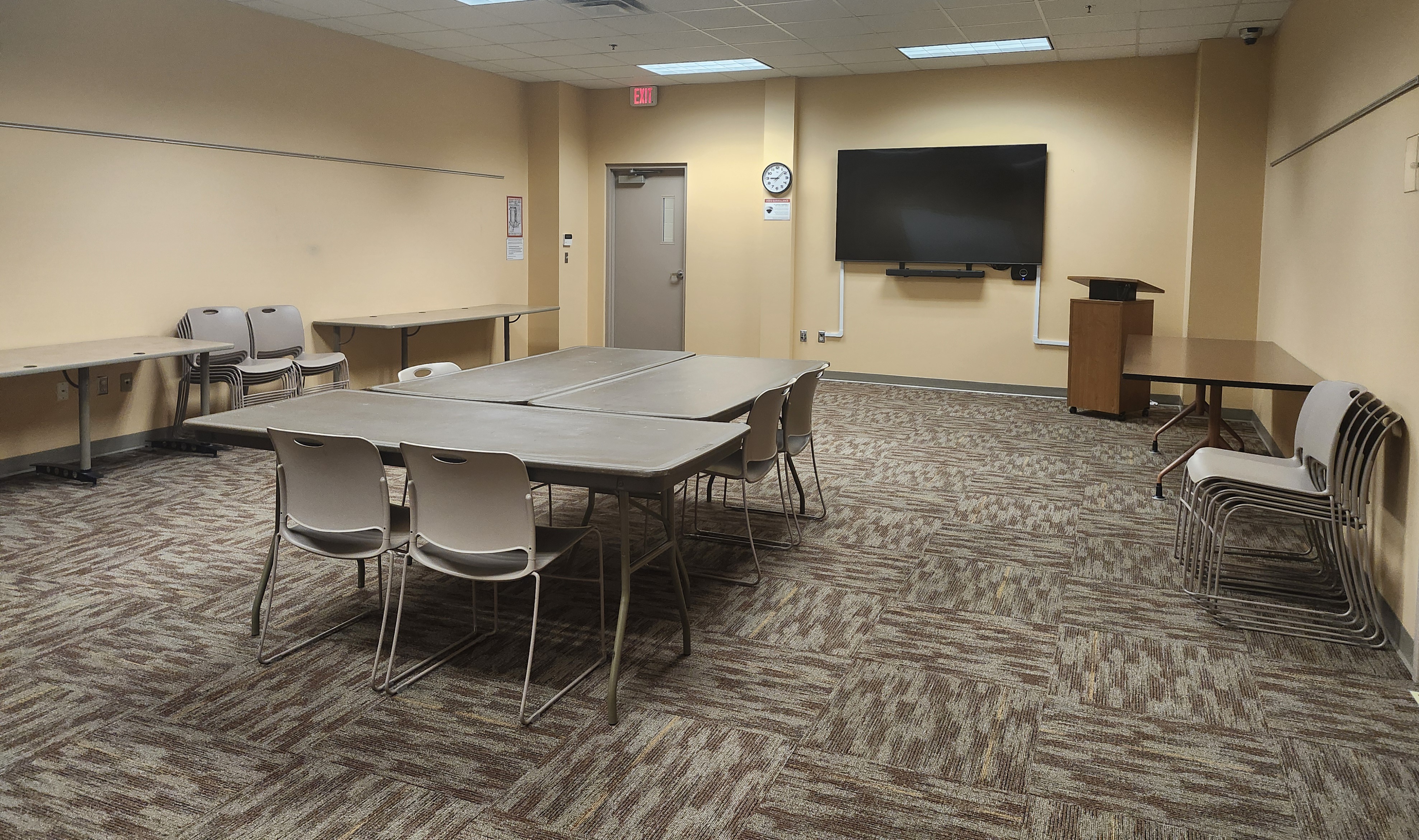 interior of the Caledonia Library meeting room include tables and chairs set up in the middle and a smart tv