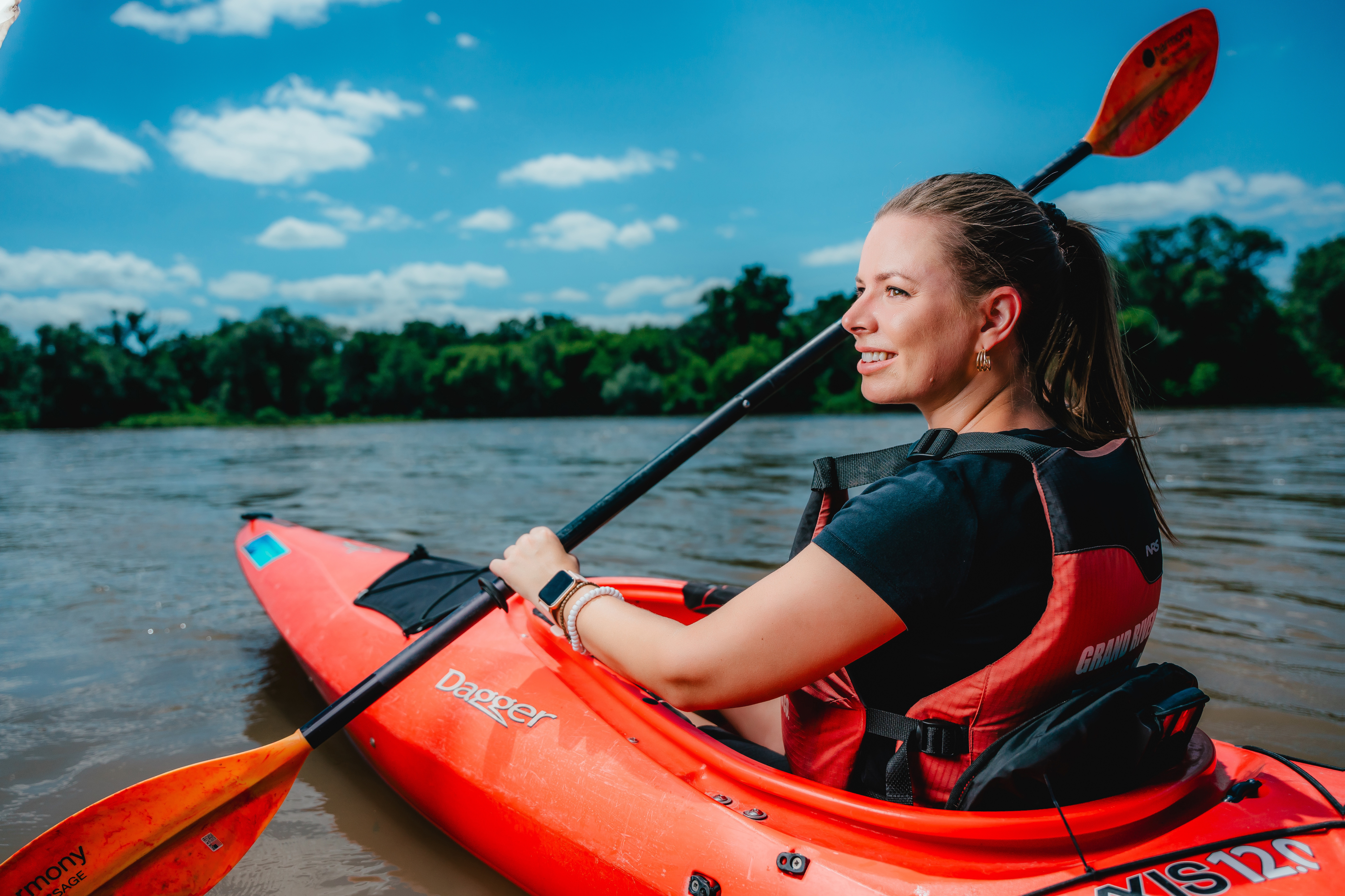 A woman paddles in a red kayak