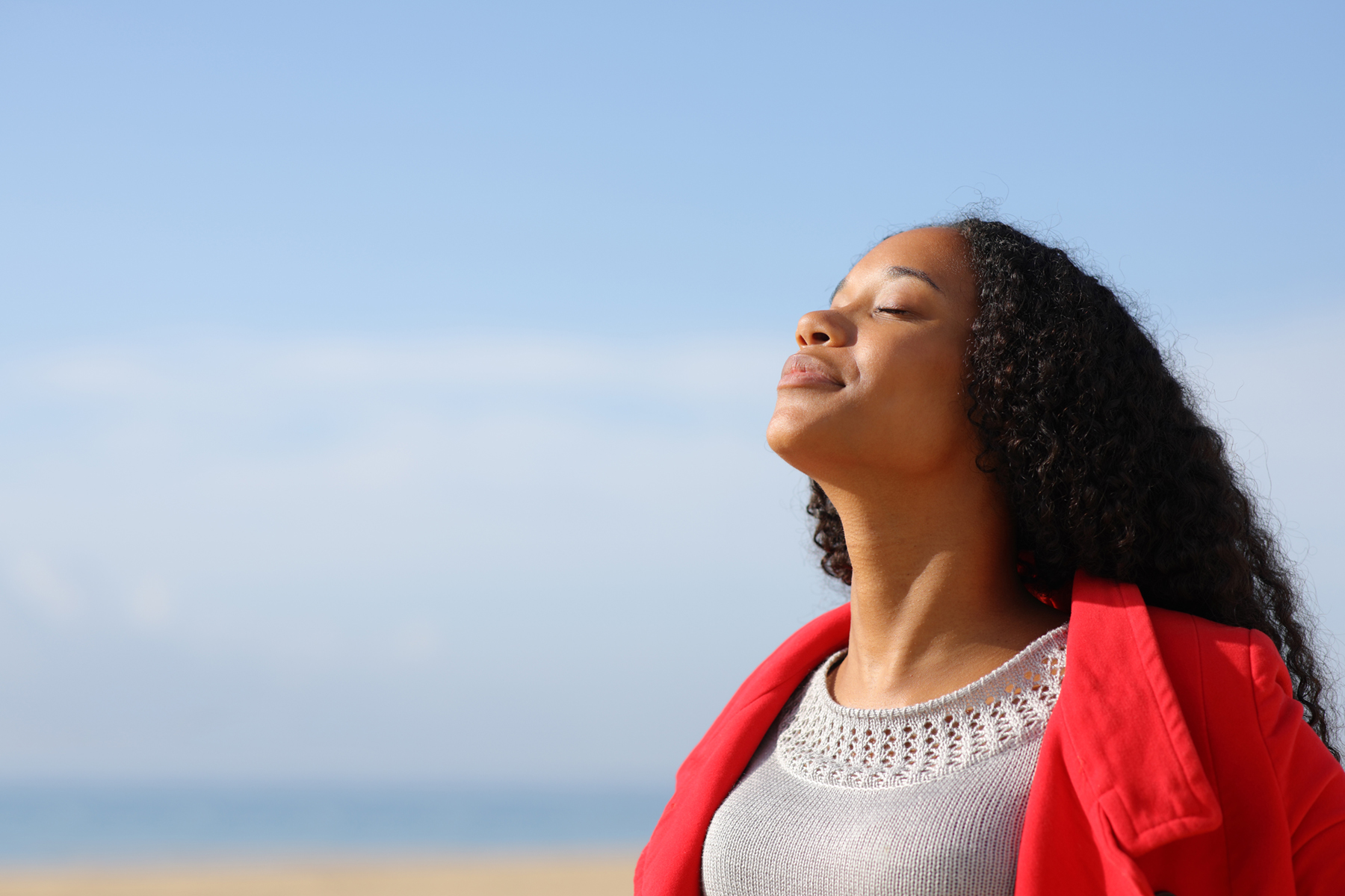 black woman facing the sky with her eyes closed