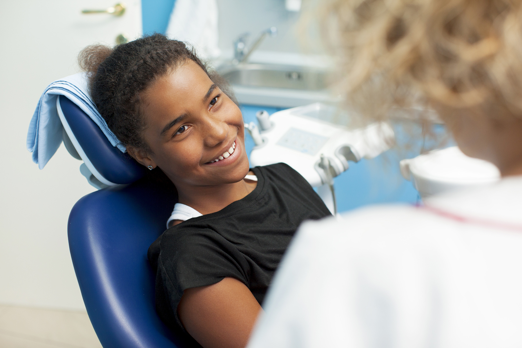 girl in dental chair with technician looking on