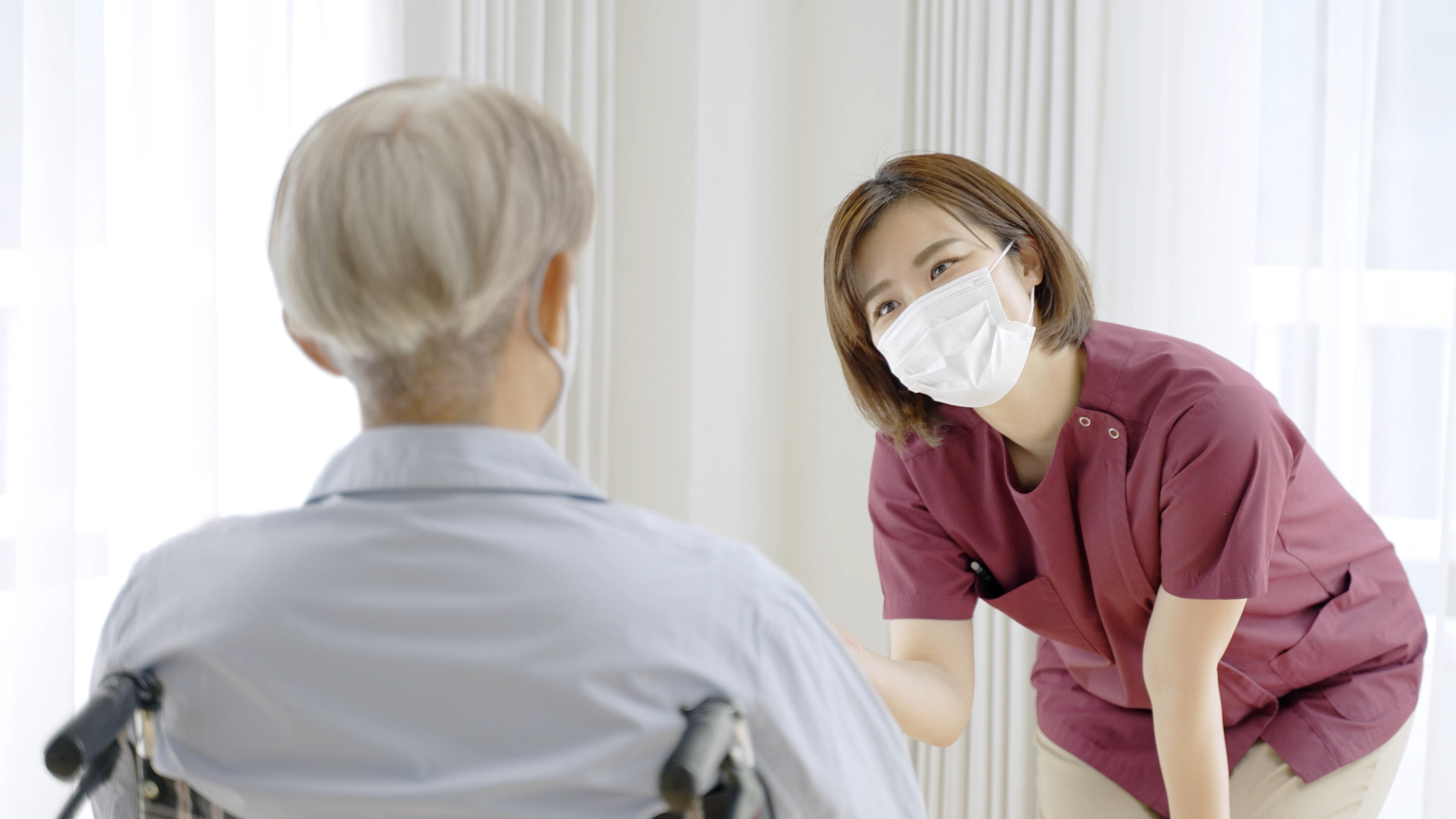 healthcare worker looking at man in wheelchair