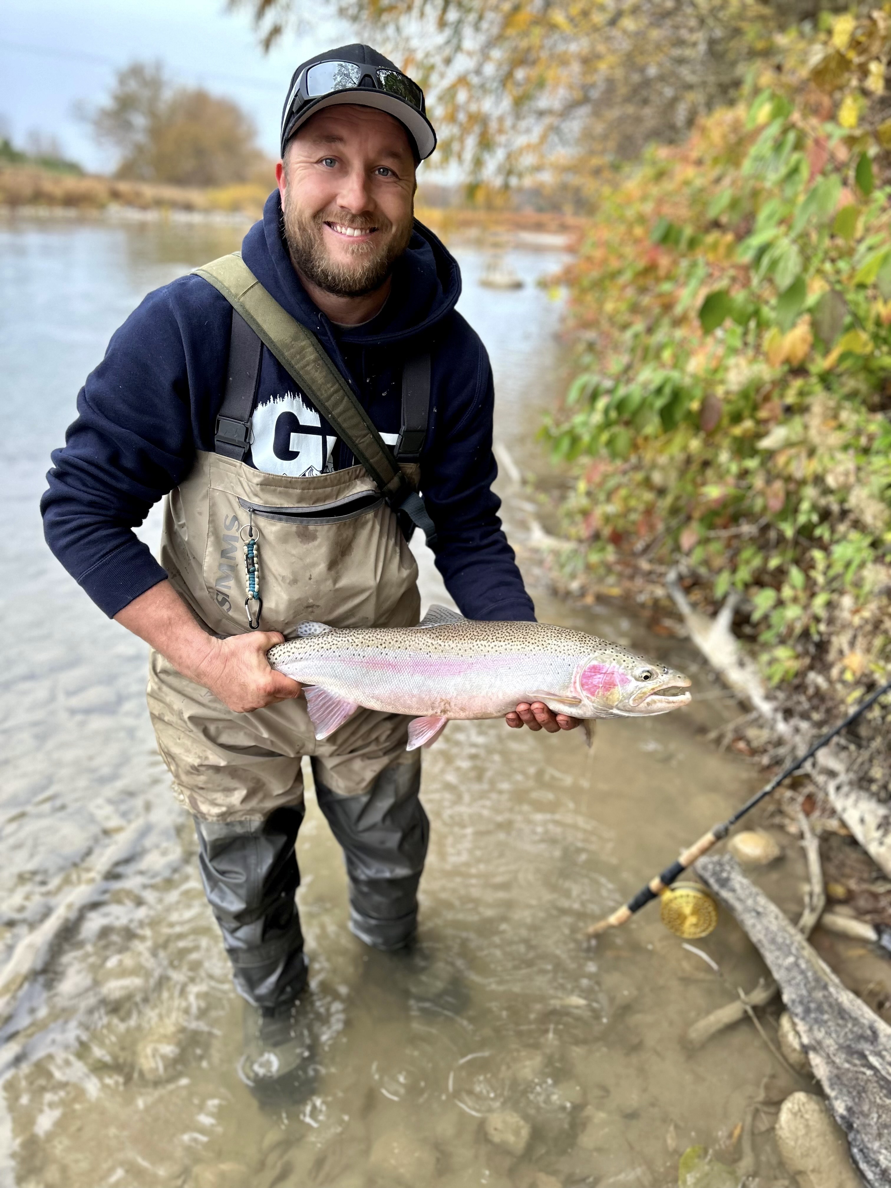 A fisherman holds a rainbow trout.