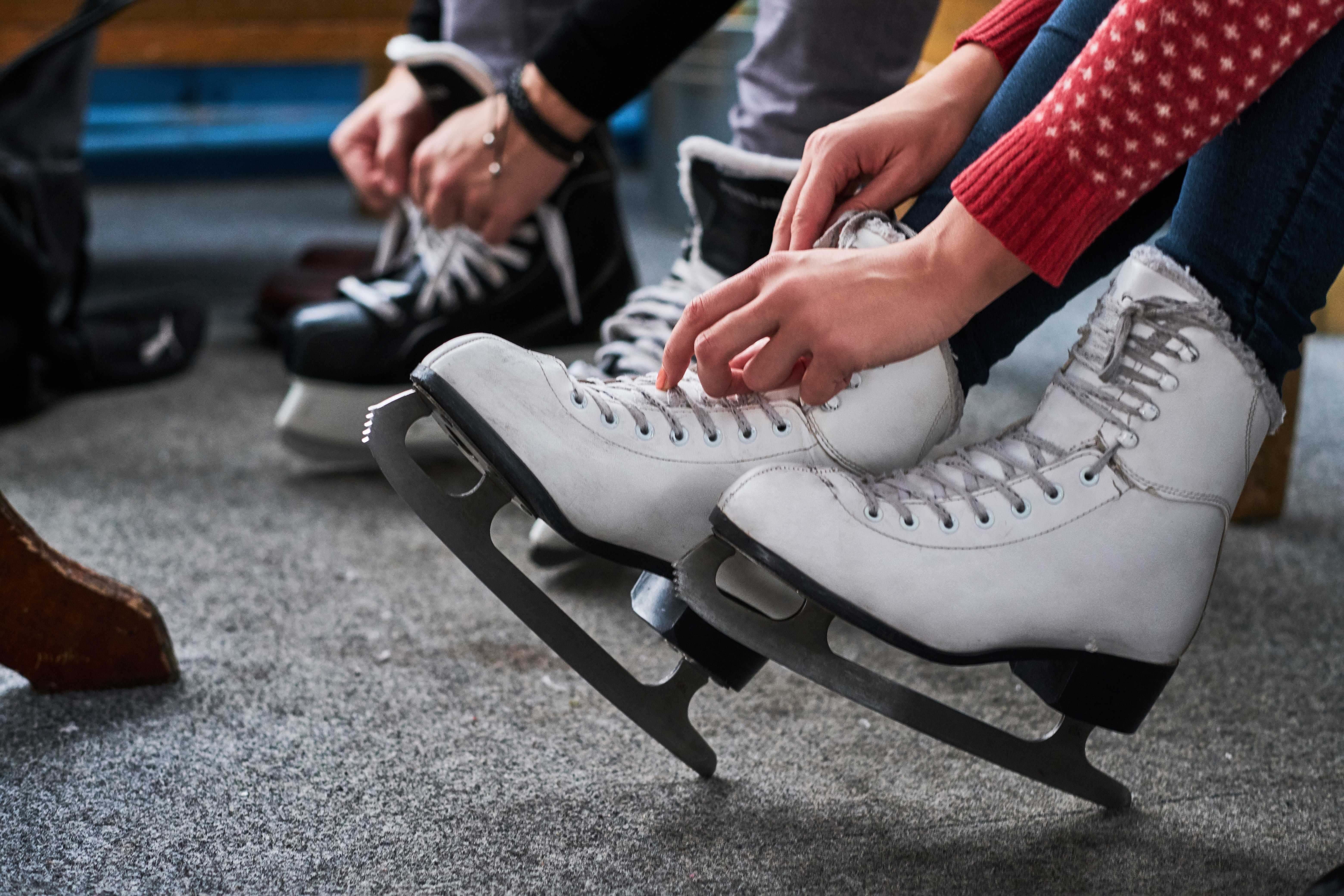 2 people lacing up skates