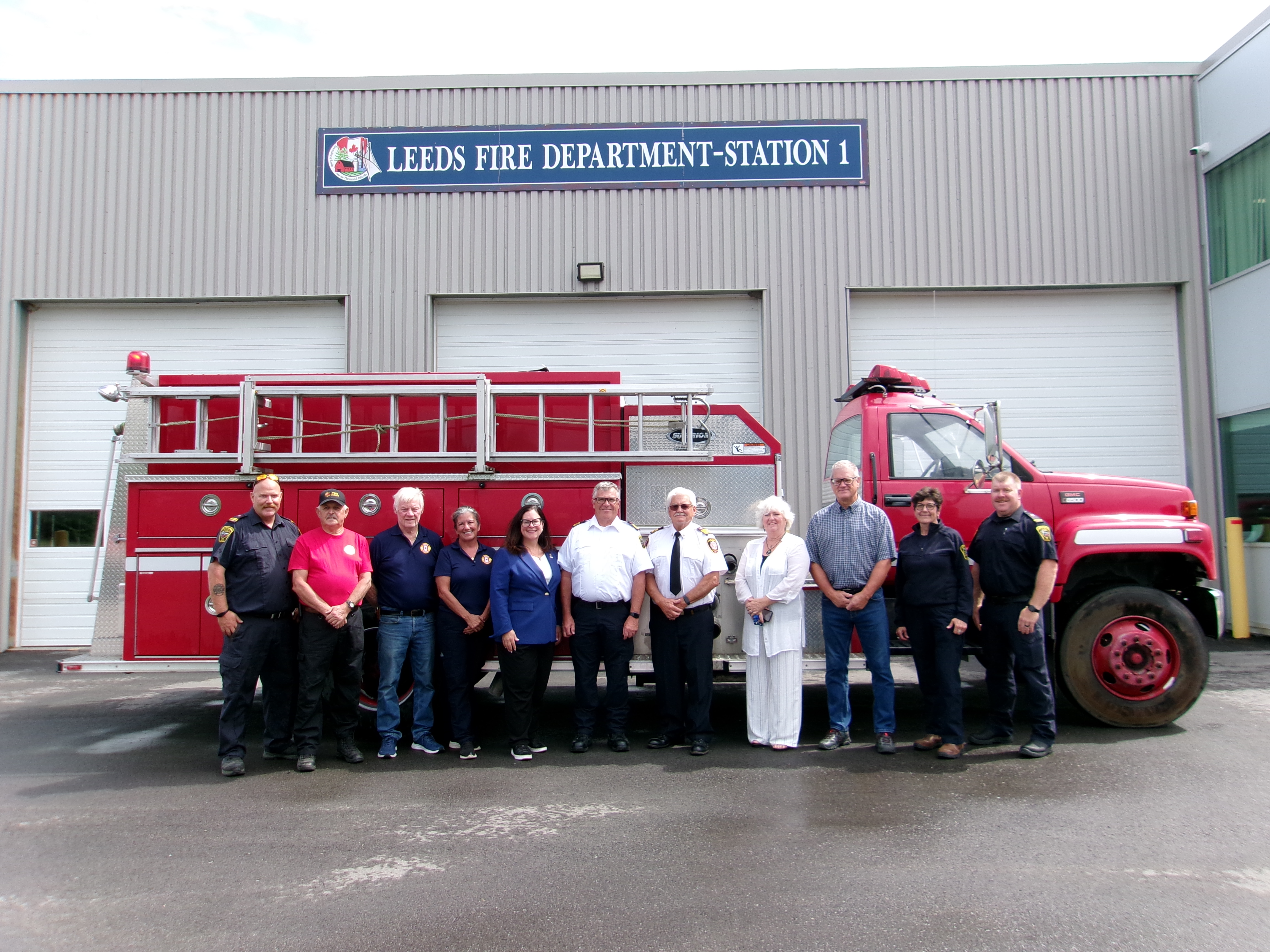 Group of fire fighters and Council members standing in front of a fire truck