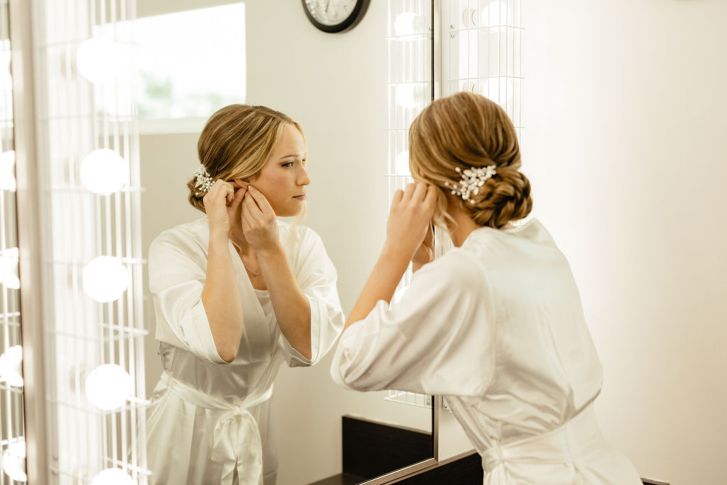 Bride looking in the mirror getting ready - Courtesy of Amanda Marie Photography