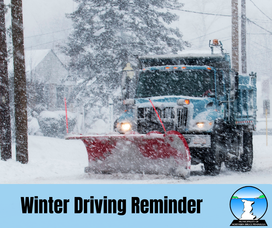 Picture of a blue snow plow on a residential street moving snow.