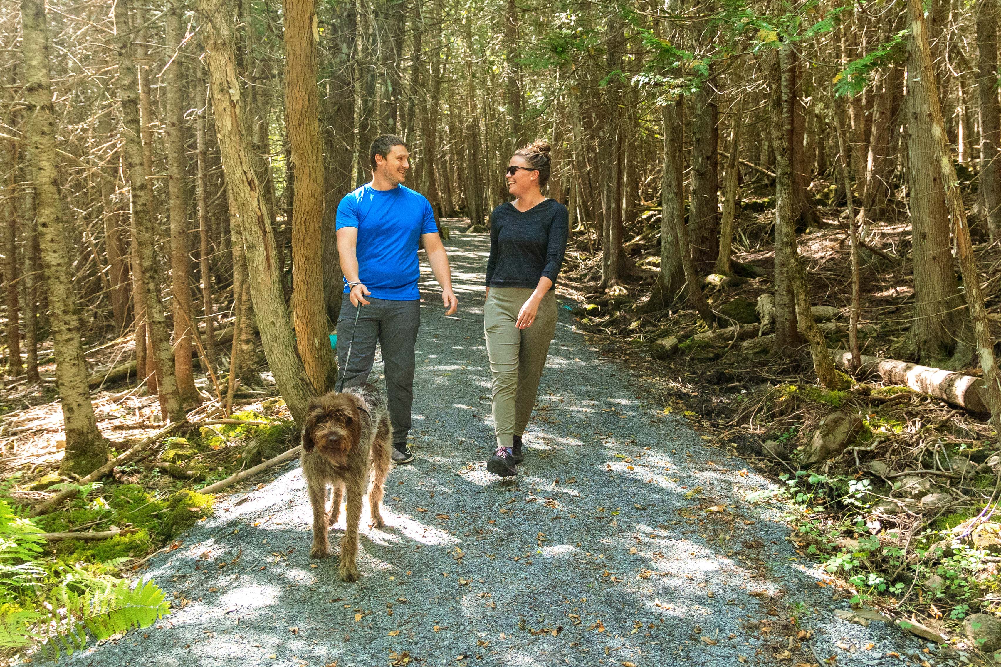 Two people enjoying walk with large dog.