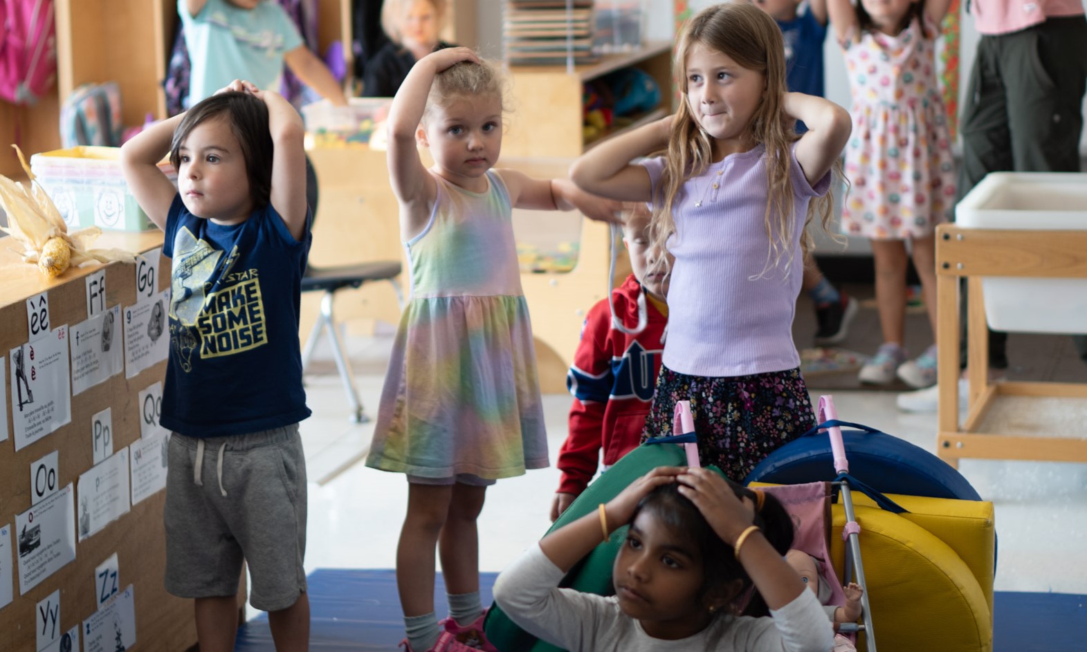 small students with hands on head playing a game
